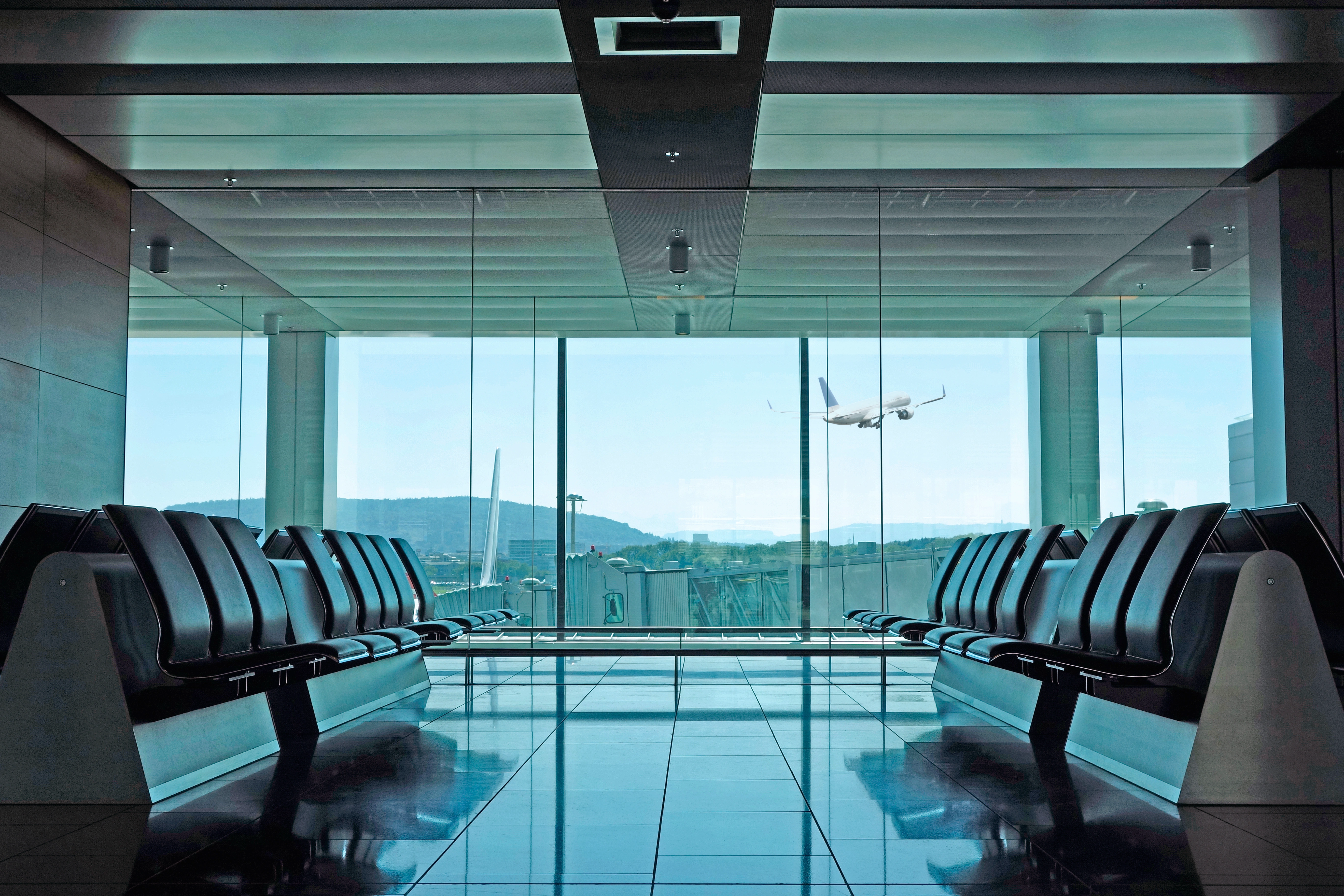 Sala de embarque de aeropuerto moderno con avión despegando — servicios de coordinación de visa.